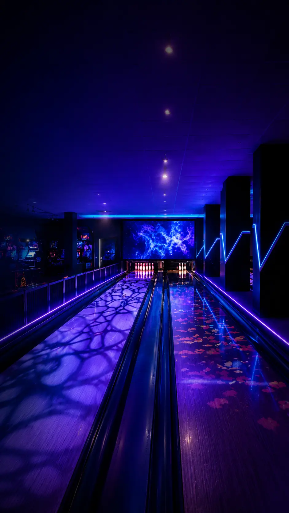 Bowler throwing on neon-lit interactive bowling lane at Game Xtreme Hyderabad